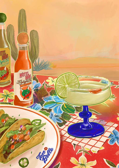 The Taco Belle Giclée Canvas Print by Hôtel Dodo features a margarita in a blue-stem glass with tacos and hot sauce on a floral tablecloth, set against cacti and a desert landscape background.